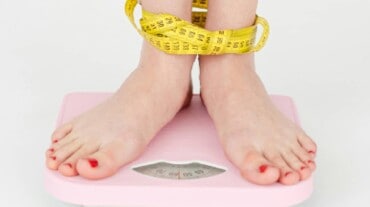 A woman on a weighing scale after doing the Bear Crawl